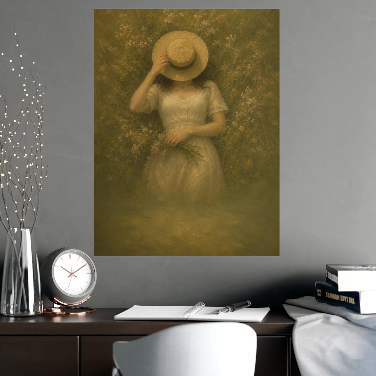 The Straw Hat — a woman lying in long grass seen from directly above, a straw hat laid over her face, shown framed on a wall