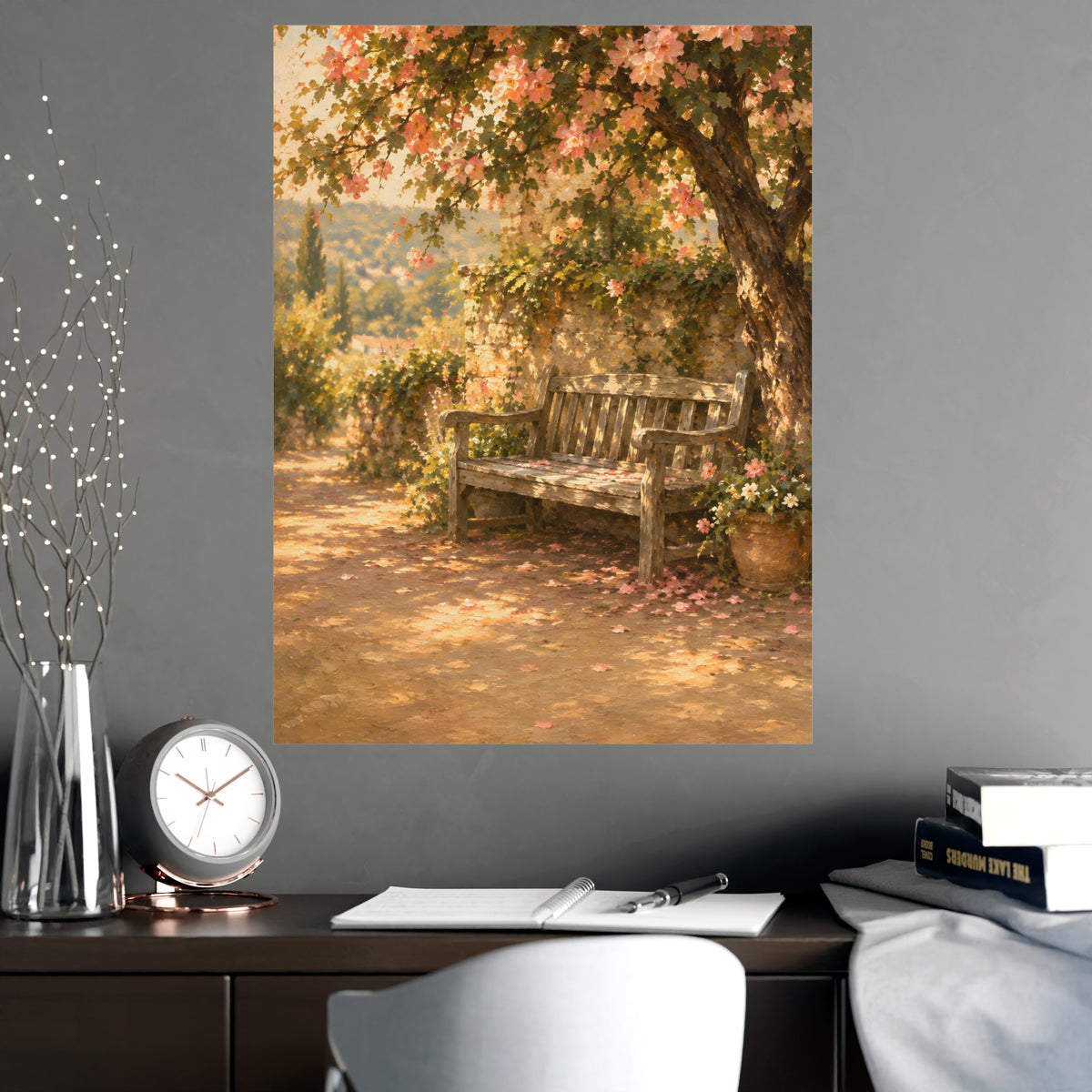 Bench Under Blossom — a weathered wooden bench under a flowering tree in a quiet garden, shown framed on a wall