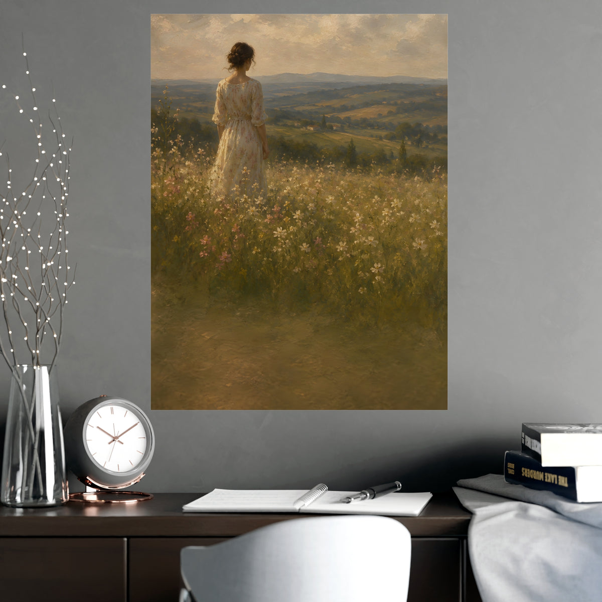 Looking to the Hills — a woman at the edge of a wildflower field looking toward distant hills, shown framed on a wall