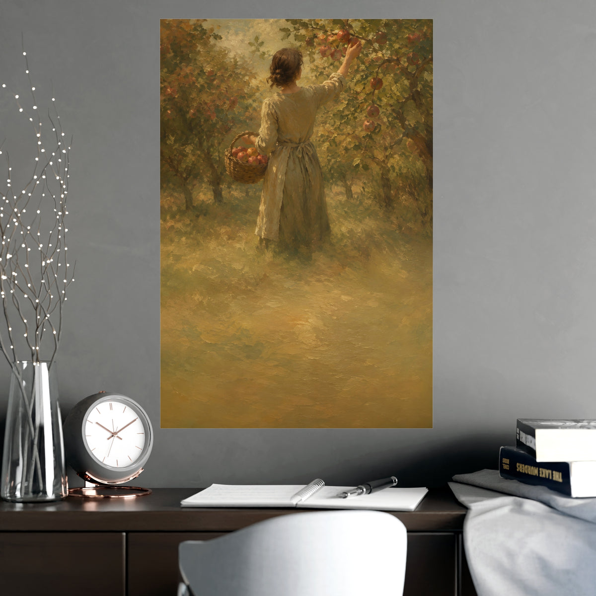 Picking Apples — a woman picking apples in an orchard in early autumn, seen from behind, shown framed on a wall