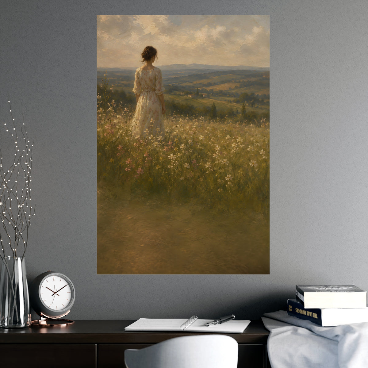 Looking to the Hills — a woman at the edge of a wildflower field looking toward distant hills, shown framed on a wall