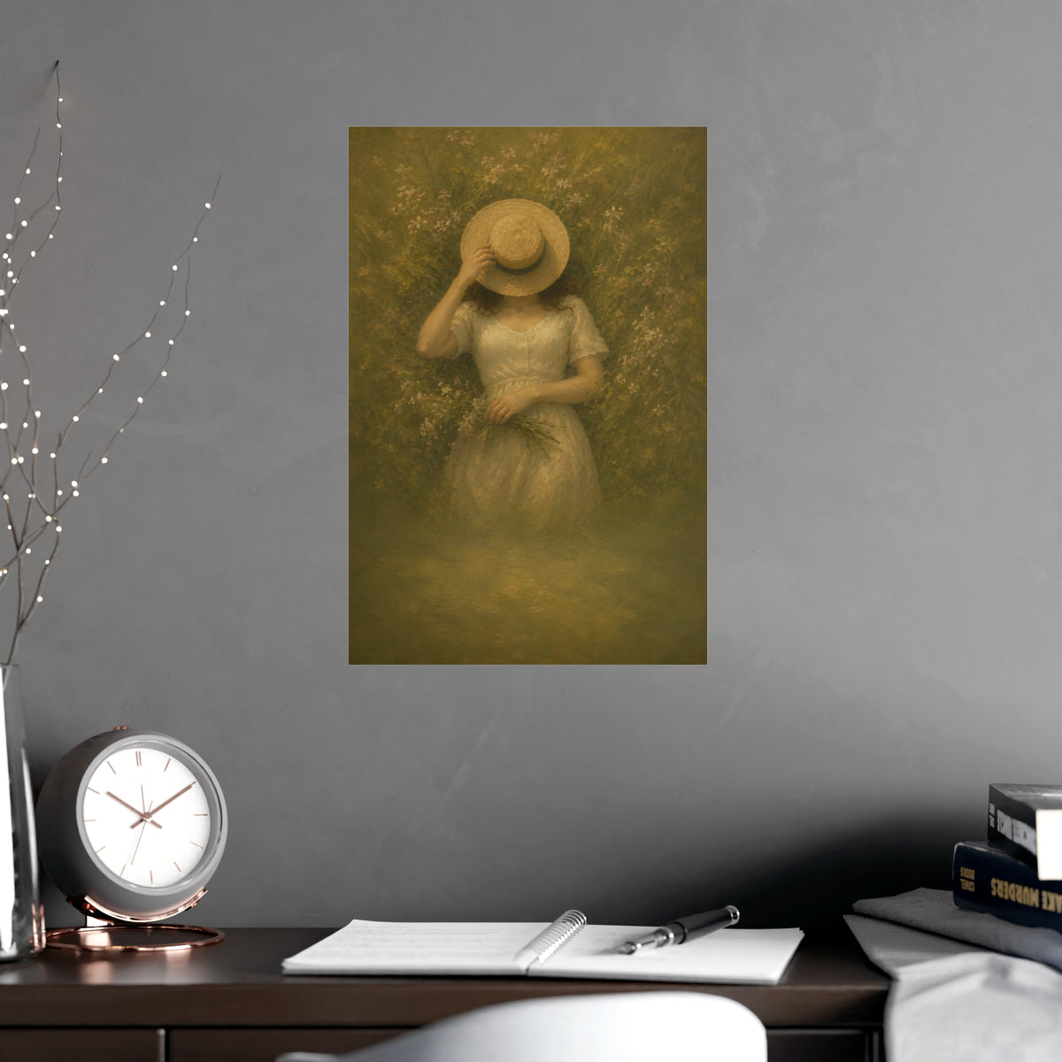 The Straw Hat — a woman lying in long grass seen from directly above, a straw hat laid over her face, shown framed on a wall