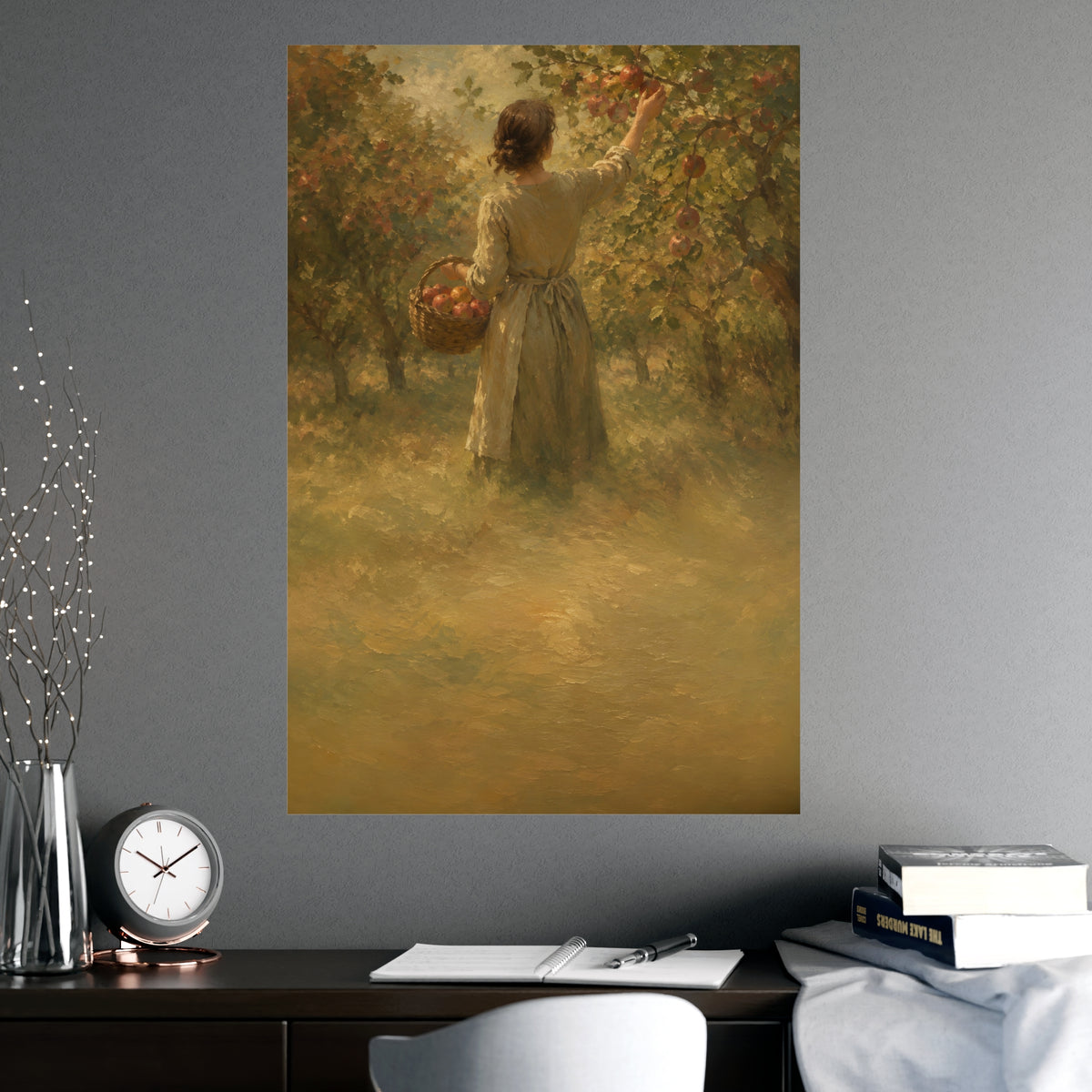 Picking Apples — a woman picking apples in an orchard in early autumn, seen from behind, shown framed on a wall