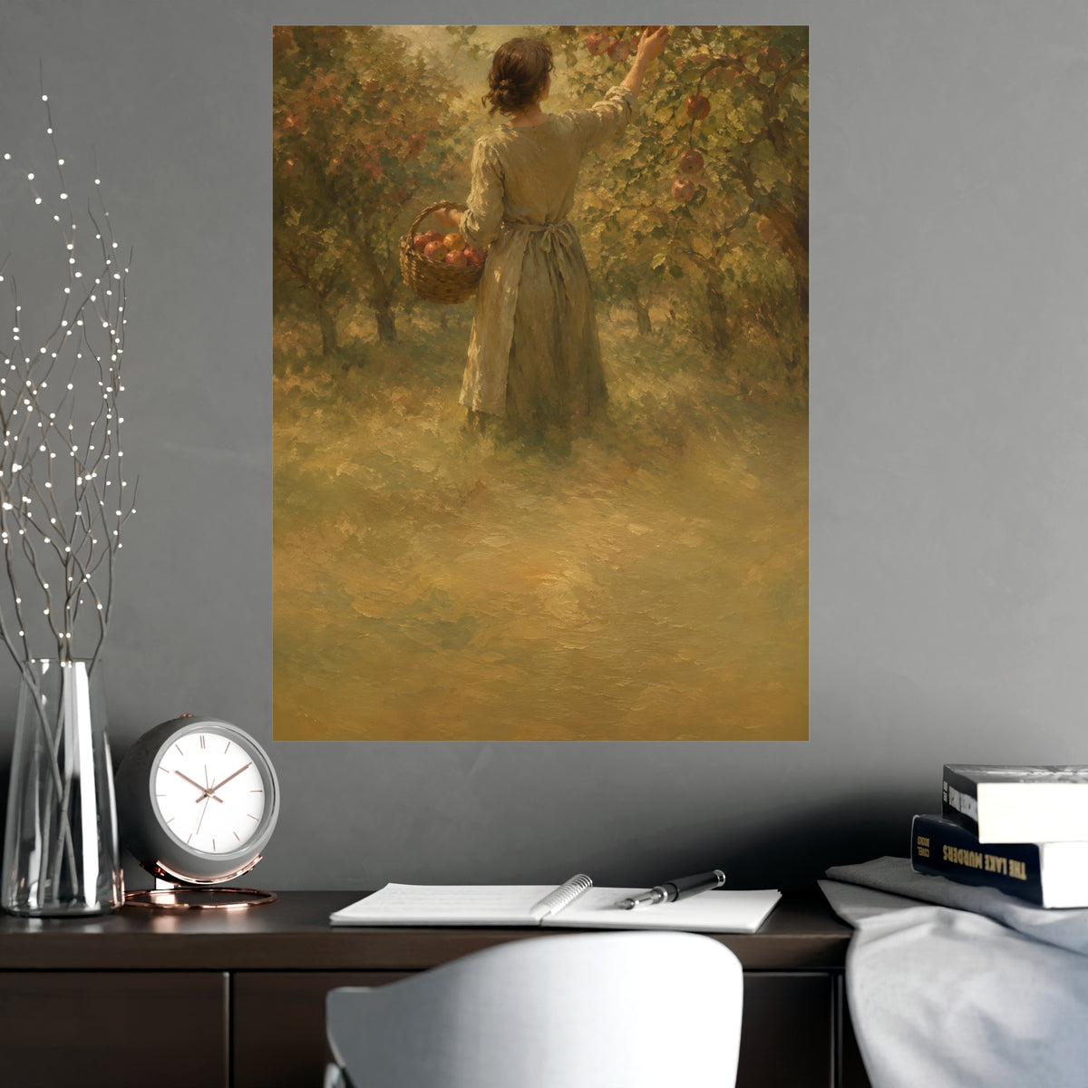 Picking Apples — a woman picking apples in an orchard in early autumn, seen from behind, shown framed on a wall