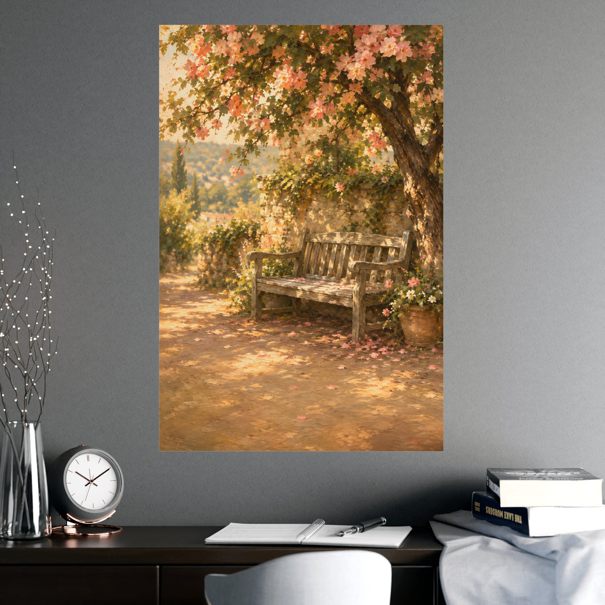 Bench Under Blossom — a weathered wooden bench under a flowering tree in a quiet garden, shown framed on a wall