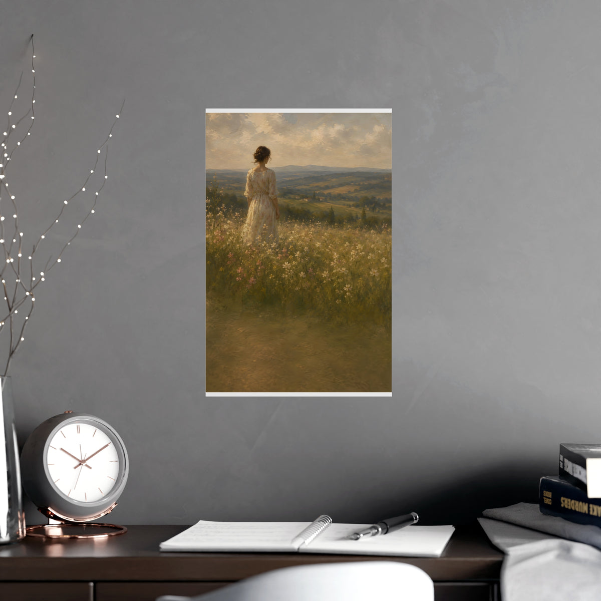 Looking to the Hills — a woman at the edge of a wildflower field looking toward distant hills, shown framed on a wall
