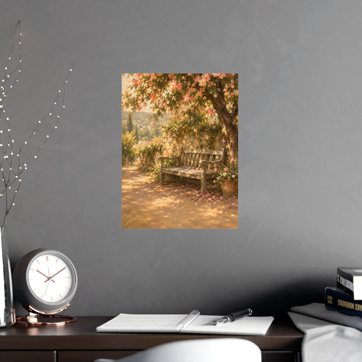 Bench Under Blossom — a weathered wooden bench under a flowering tree in a quiet garden, shown framed on a wall