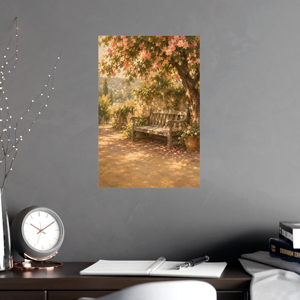 Bench Under Blossom — a weathered wooden bench under a flowering tree in a quiet garden, shown framed on a wall