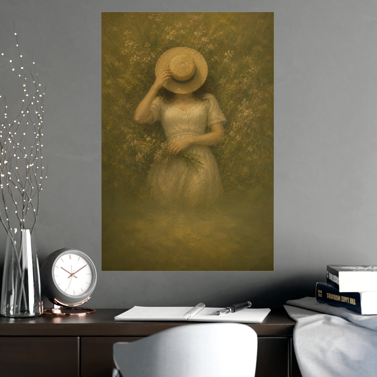 The Straw Hat — a woman lying in long grass seen from directly above, a straw hat laid over her face, shown framed on a wall