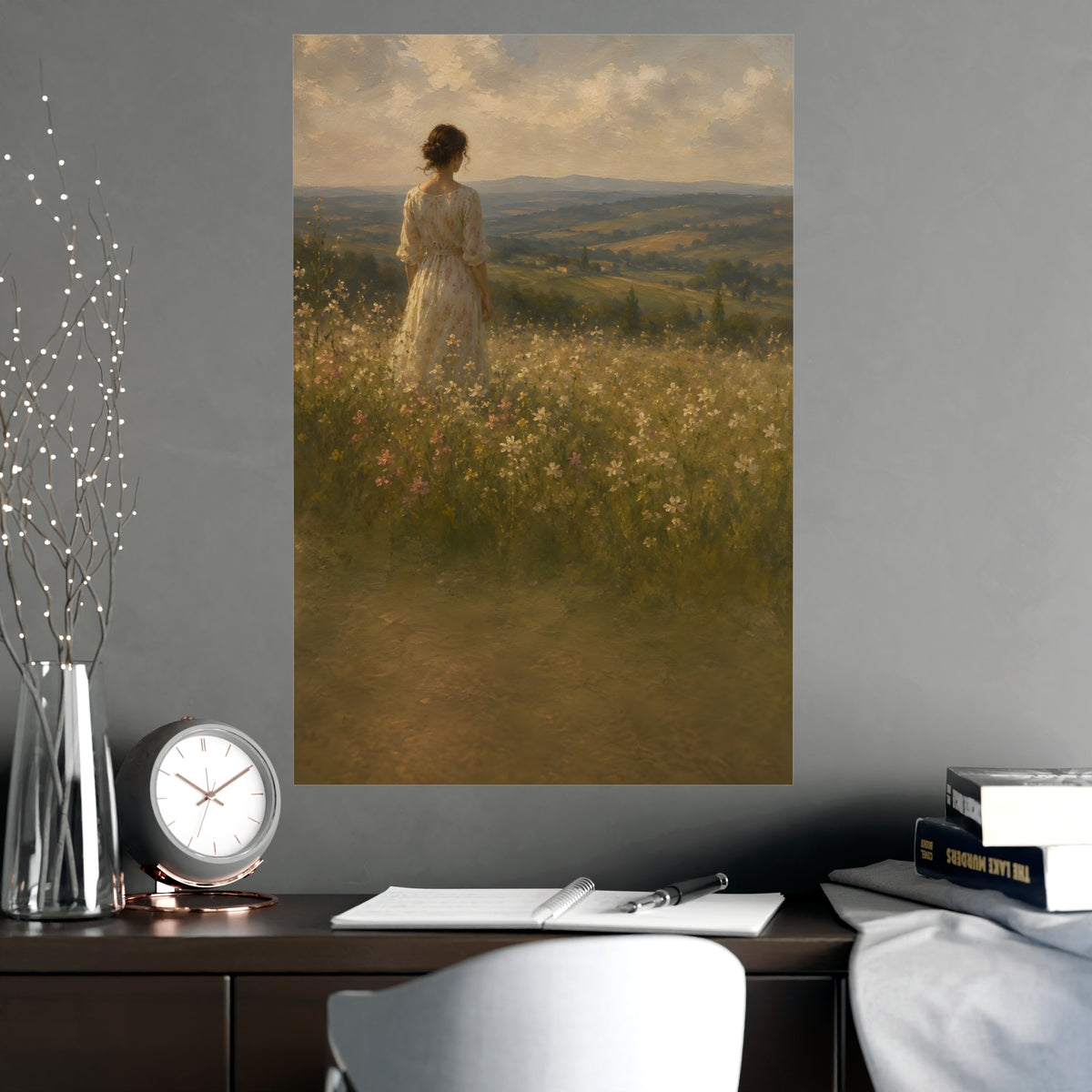 Looking to the Hills — a woman at the edge of a wildflower field looking toward distant hills, shown framed on a wall