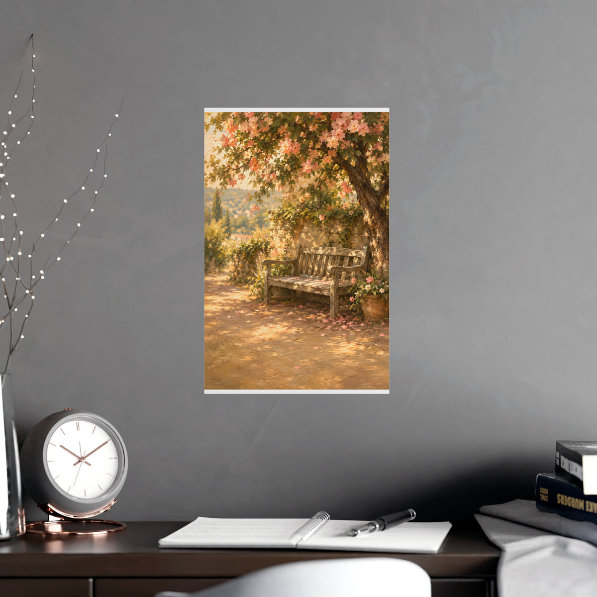 Bench Under Blossom — a weathered wooden bench under a flowering tree in a quiet garden, shown framed on a wall